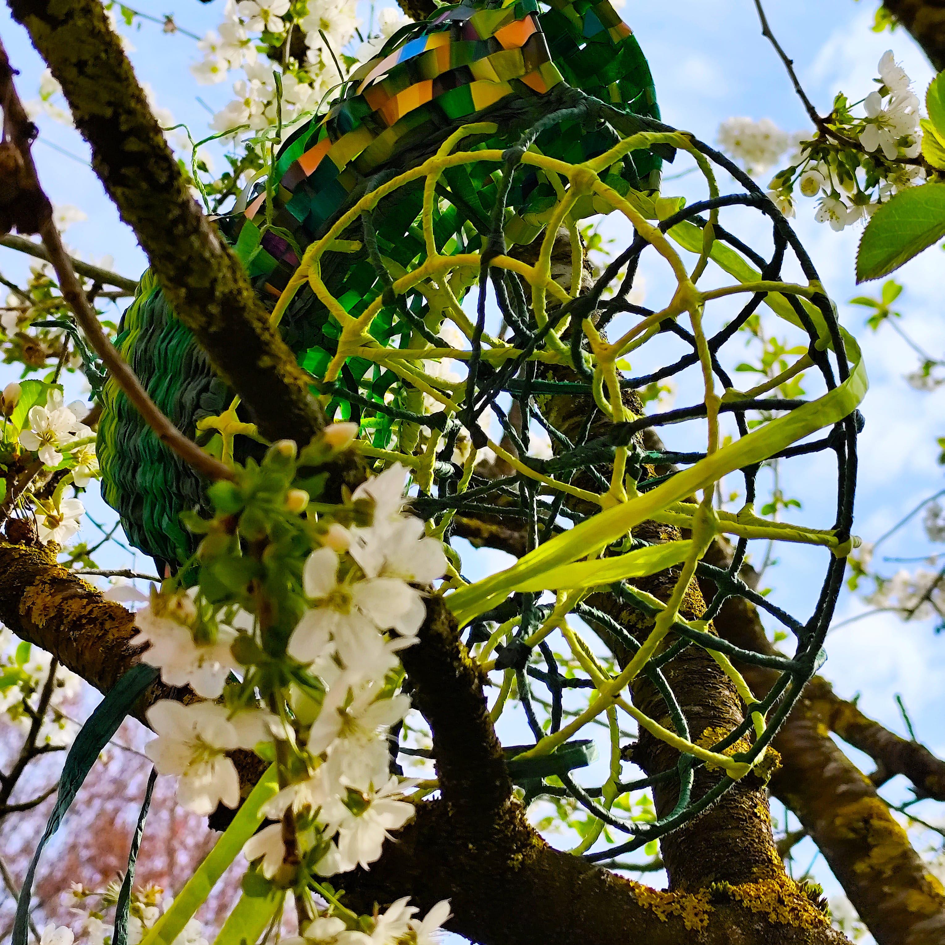 Anne Reinke: Frühling. 2026, Hängeobjekt, gemalt, gewebt und geflochten, Papier, Bast, Draht, Metallgestell